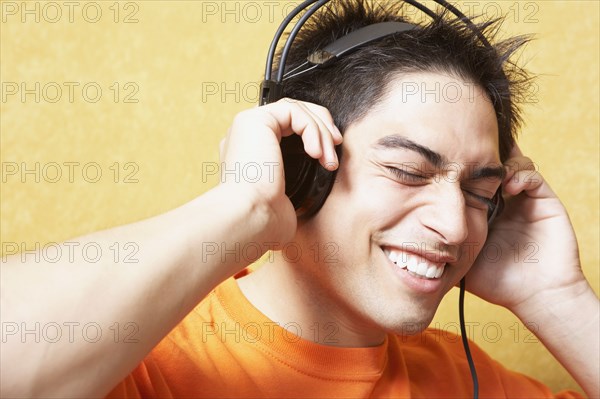 Hispanic man listening to headphones