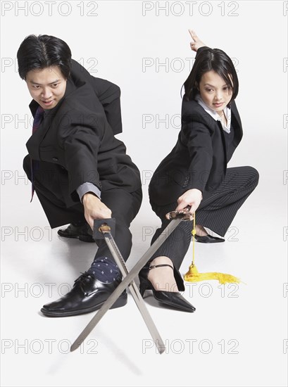Studio shot of Asian businesspeople with crossed swords