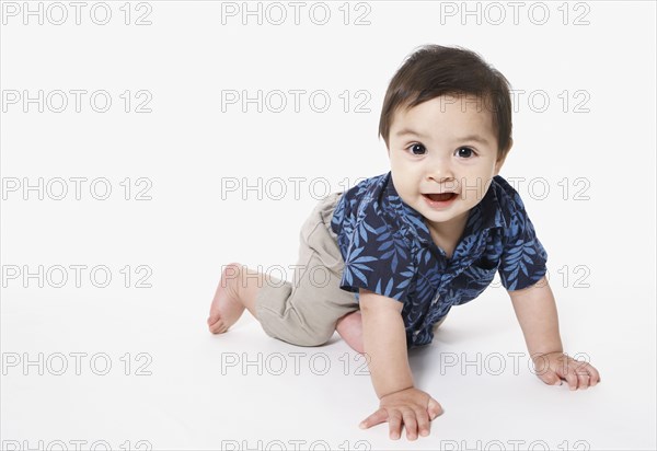 Studio shot of toddler boy crawling