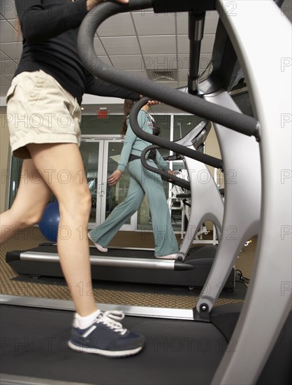 Multi-ethnic women walking on treadmills