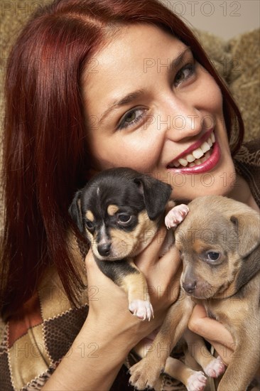 Hispanic woman hugging puppies