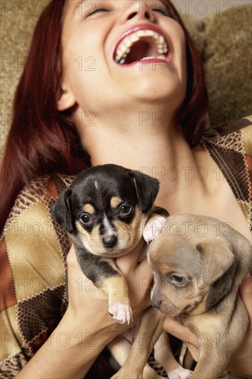 Hispanic woman holding puppies