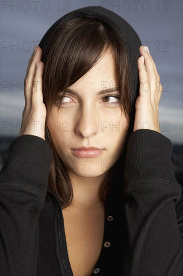 Hispanic woman covering ears with hands