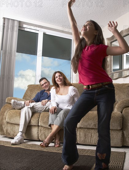 Hispanic girl dancing for parents