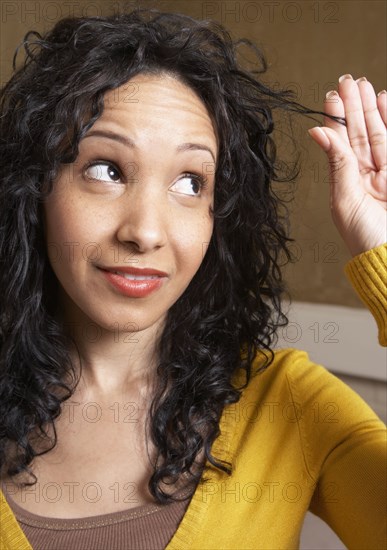 Hispanic woman playing with hair