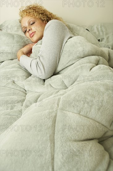 Young woman sleeping in bed