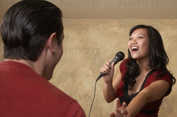 Asian woman singing with microphone