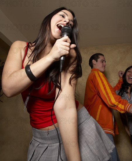 Hispanic woman singing with microphone