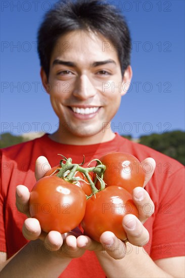 Pacific Islander man holding tomatoes