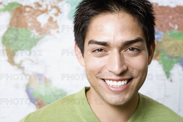Portrait of Pacific Islander man in front of world map