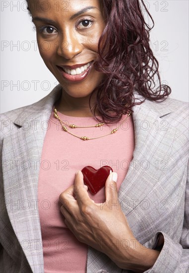 African woman holding heart up to chest