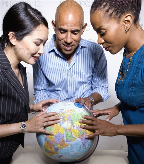 Multi-ethnic businesspeople looking a globe
