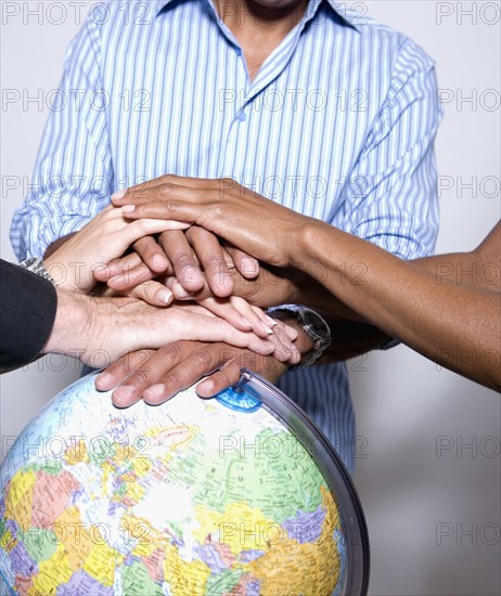 Multi-ethnic businesspeople with hands on globe