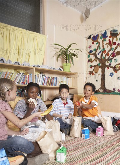 Multi-ethnic school children eating lunch