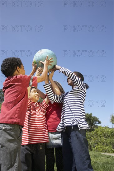 Multi-ethnic children holding globe