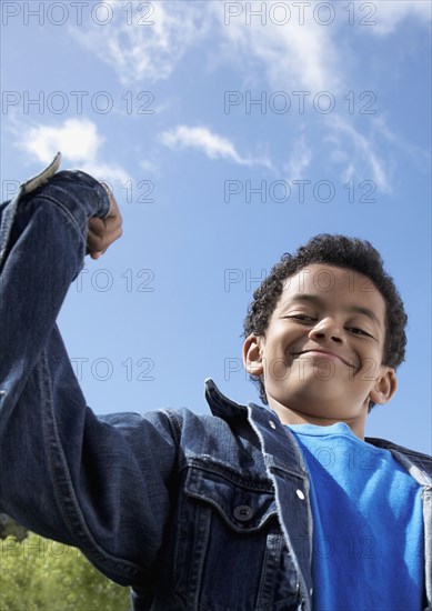 Mixed Race boy flexing muscles