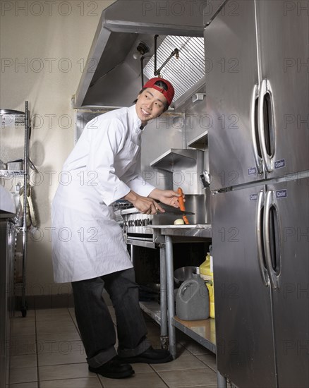 Asian male chef chopping vegetables