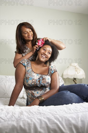 African American mother putting flower in daughter's hair