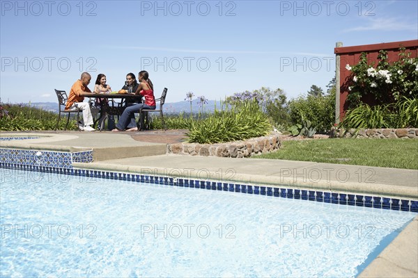 Multi-ethnic couples sitting at outdoor table