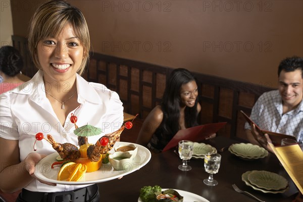 Asian female server holding plate of food