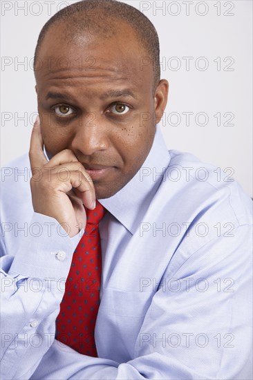 African American businessman leaning chin on hand