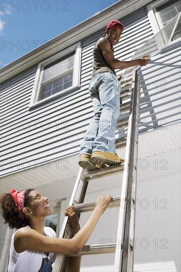 African American couple replacing window screens