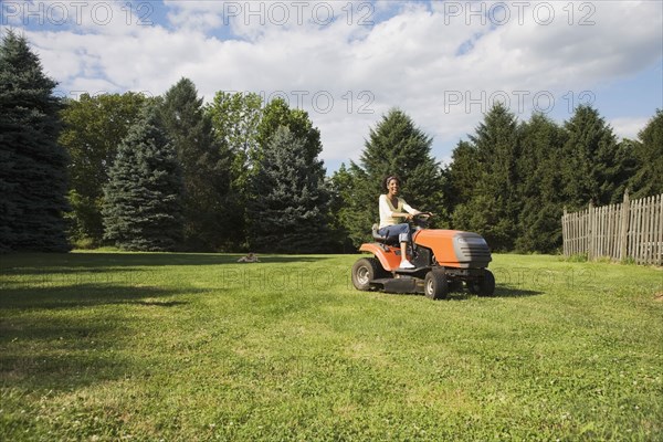 African American woman mowing lawn