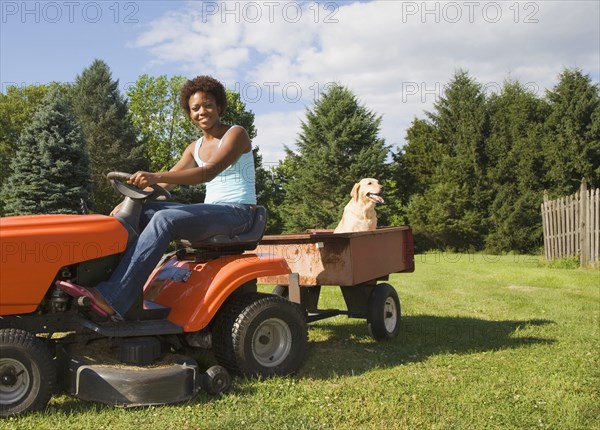 African American woman mowing lawn