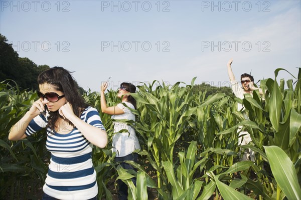 Middle Eastern people using cell phones in corn field