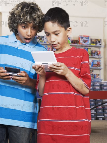 Multi-ethnic boys playing handheld video games