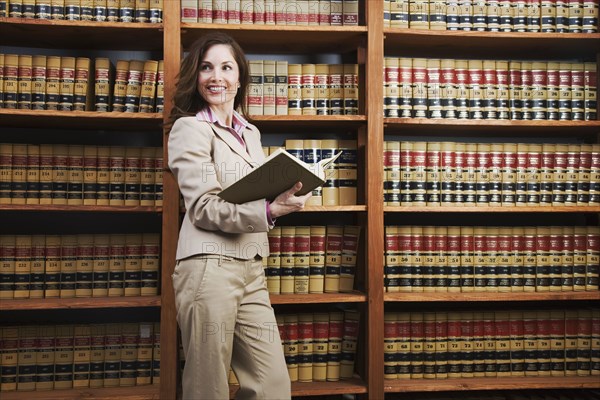 Hispanic woman reading library reference book