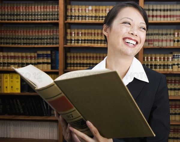 Asian woman holding library reference book