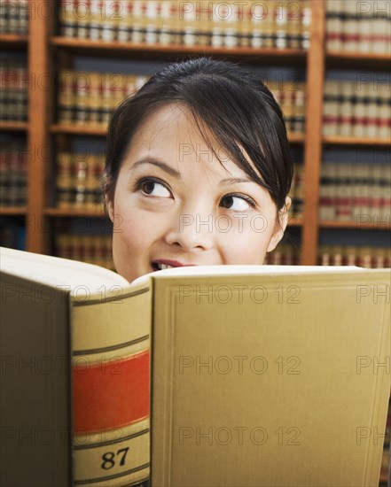 Asian woman holding library reference book