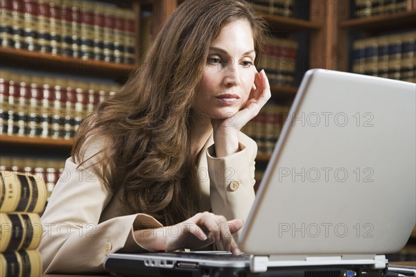 Hispanic woman looking at laptop