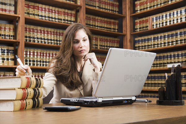 Hispanic woman looking at laptop