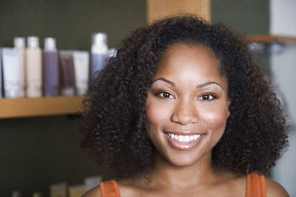 African American woman in front of hair care products