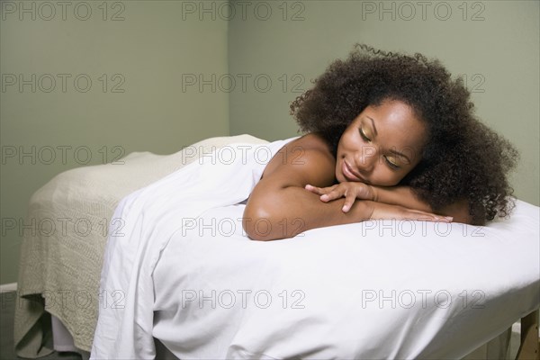 African woman laying on massage table