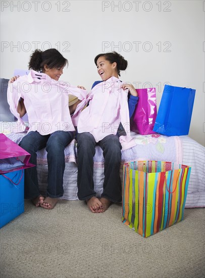 African twin sisters comparing shirts