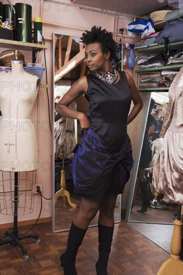 African woman trying on dress at dress making shop