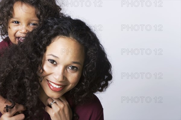 Mixed Race mother giving son piggy back ride