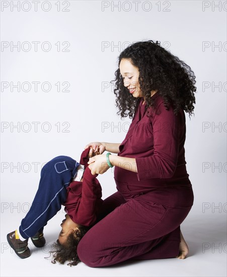 Pregnant Mixed Race mother playing with son