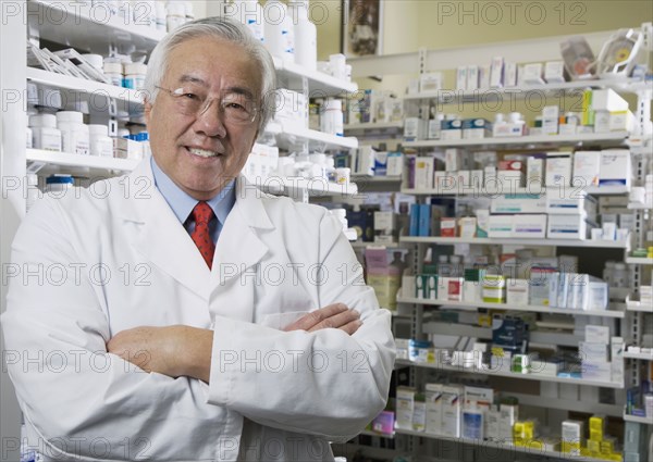 Senior Asian pharmacist with arms crossed