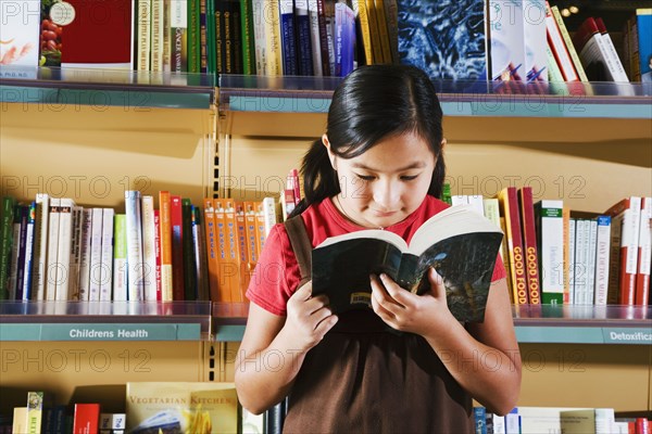 Asian girl reading in store