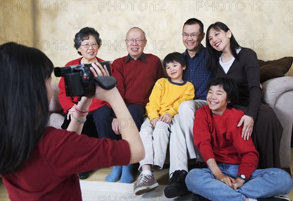Multi-generational Asian family being video recorded