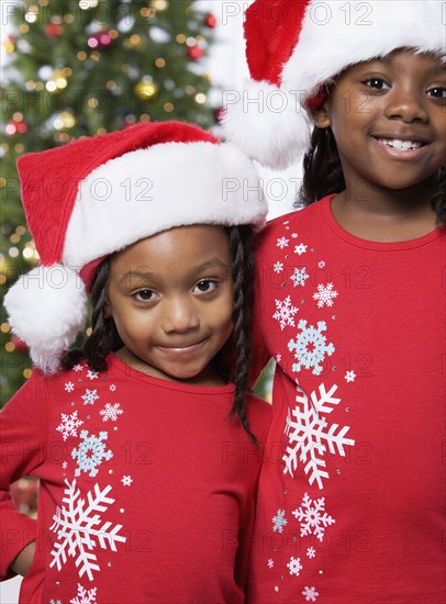 African sisters wearing Santa Claus hats