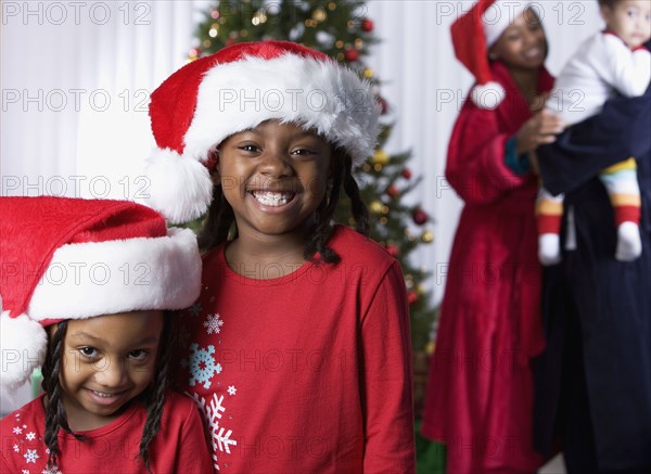 African sisters wearing Santa Claus hats