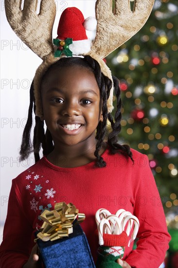 African girl holding Christmas gifts