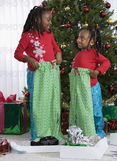 African sisters holding matching Christmas gifts