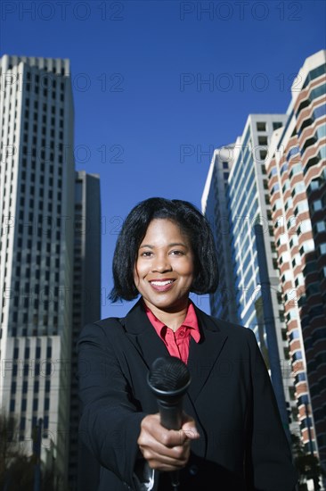 African female reporter holding microphone