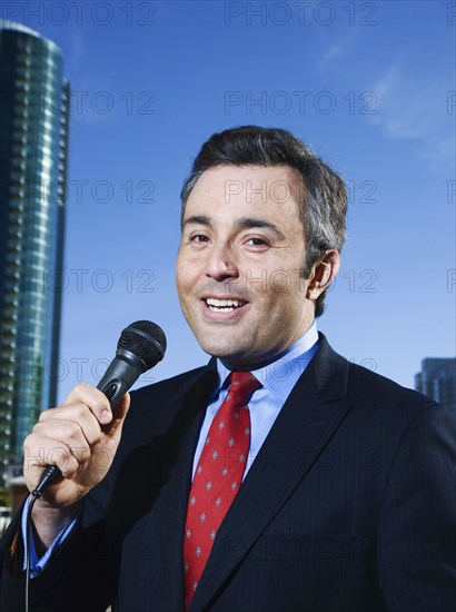 Hispanic male reporter holding microphone